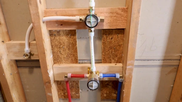 Plumber repairing a pipe connection behind a Sebastian, FL wall
